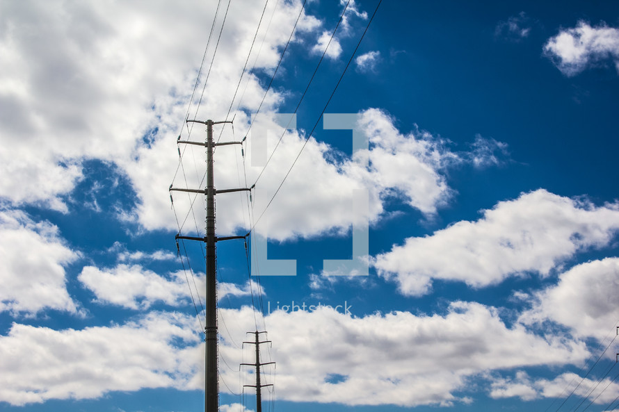 power lines and power pole with clouds in a blue sky 