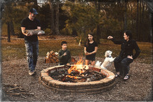 family roasting marshmallows by a fire 