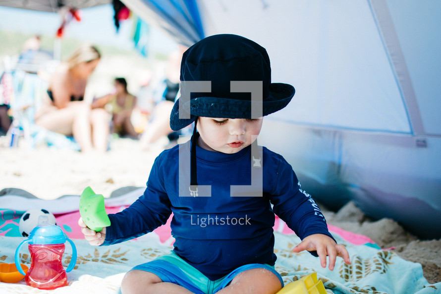 a toddler playing in a tent at the beach 