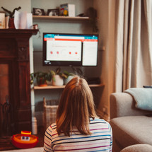 a woman watching an online worship service at home 