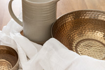 Water pitcher and copper bowls with a white linen cloth with copy space
