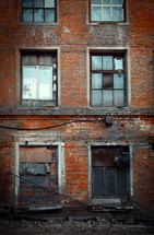 broken windows on an abandoned brick building 
