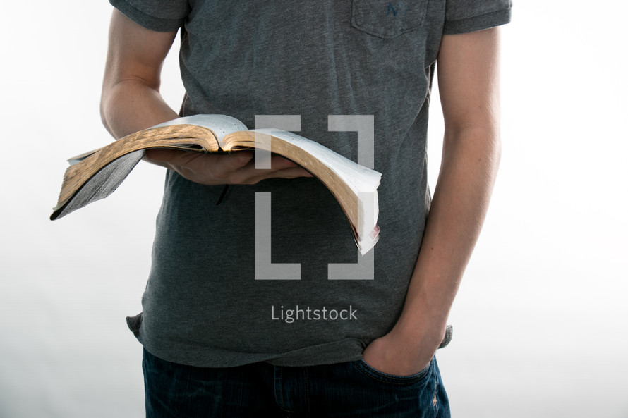 Teen holding an open Bible.