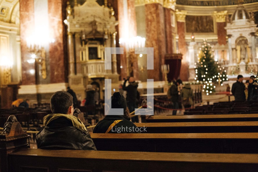 people sitting in pews of a cathedral at Christmas 