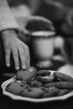 hand reaching for a plate of cookies 