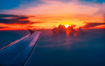 wing of a plane in flight at sunset 