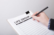 A man signing up to in a life group 