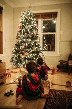 boys playing under a Christmas tree 