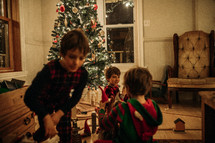 children playing around a Christmas tree 