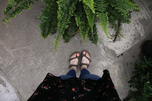 feet next to a fern 