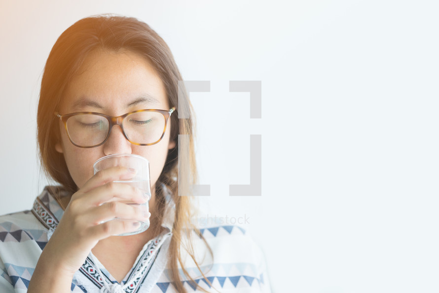 a young woman drinking a glass of water 