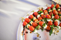 appetizers on a tray, tomato, basil, and mozzarella 