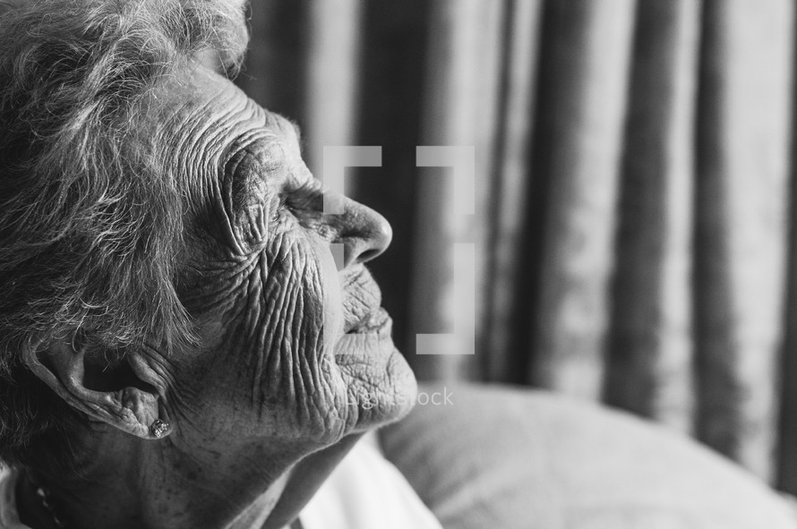 Light shining on the profile of an elderly woman.