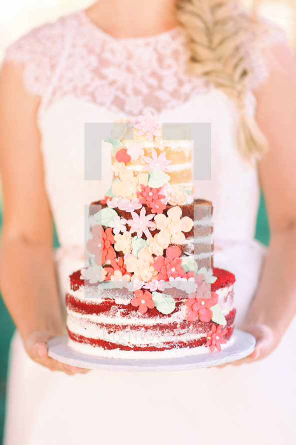 bride holding a wedding cake 