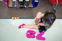 girl child trying on shoes 