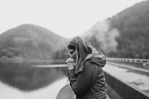 a woman praying on a bridge 