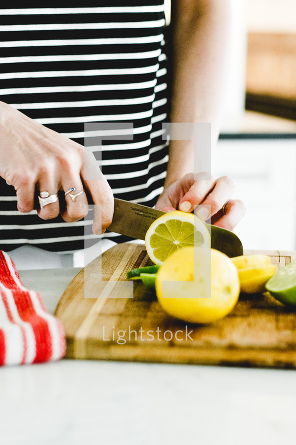 slicing a lemon and lime in a kitchen 