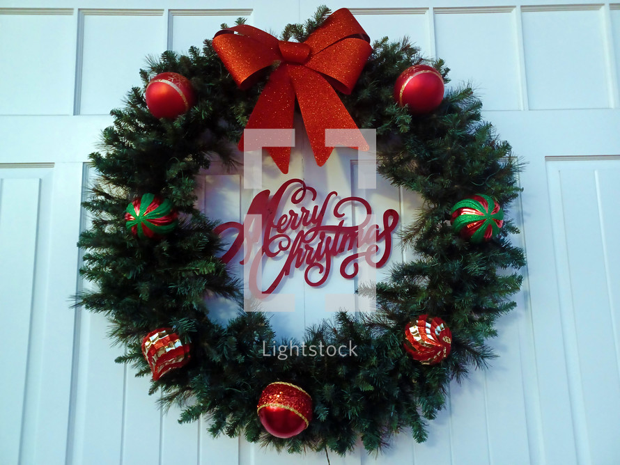 Merry Christmas wreath on a white door background