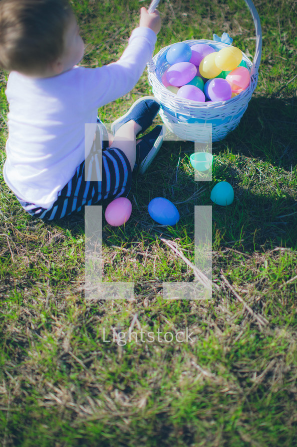 toddler boy playing with an Easter basket