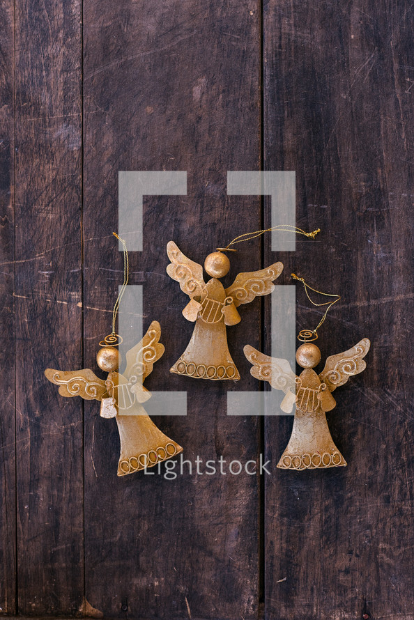 gold angel ornaments on wood background 