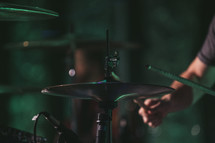 a man on stage behind cymbals 