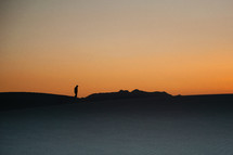 silhouette of a man on sand dunes 
