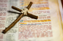 Rustic handmade cross laying by John 15:13 scripture in Bible that says, "Greater love has no one than this, that one lay down his life for his friends."