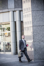 businessman walking with a briefcase and coffee cup 