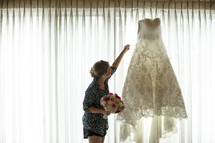wedding gown hanging in a window 