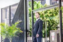 portrait of a businessman standing in front of a glass door 