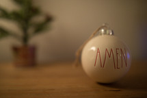 Amen Christmas ornament on a wood background 