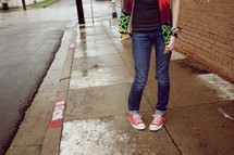 A teenager standing on a sidewalk