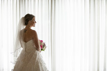 bride standing at a window 