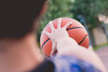 teen boy gripping a basketball 