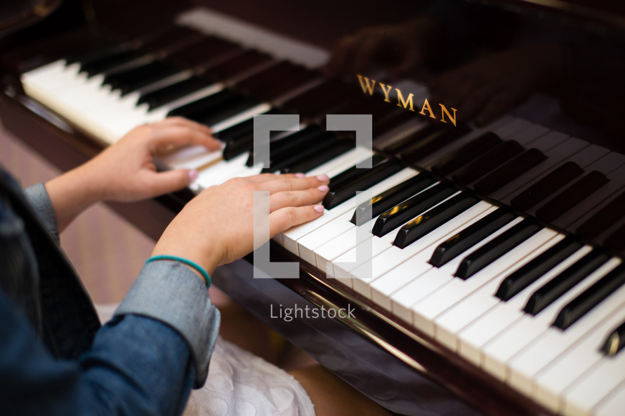 Hands of a woman, playing a piano