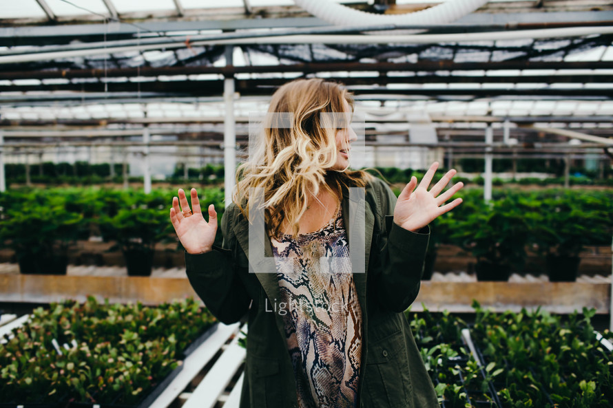 a woman standing in a garden center greenhouse 