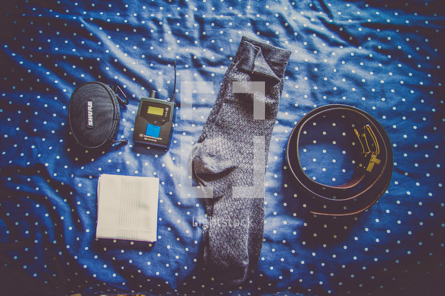 socks, handkerchief, belt, sound equipment on a bed
