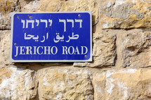 Jericho Road sign in Hebrew, Arabic and English on a stone wall in the Old City of Jerusalem.
