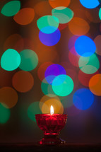 colorful bokeh lights and a candle