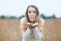 young woman blowing confetti 
