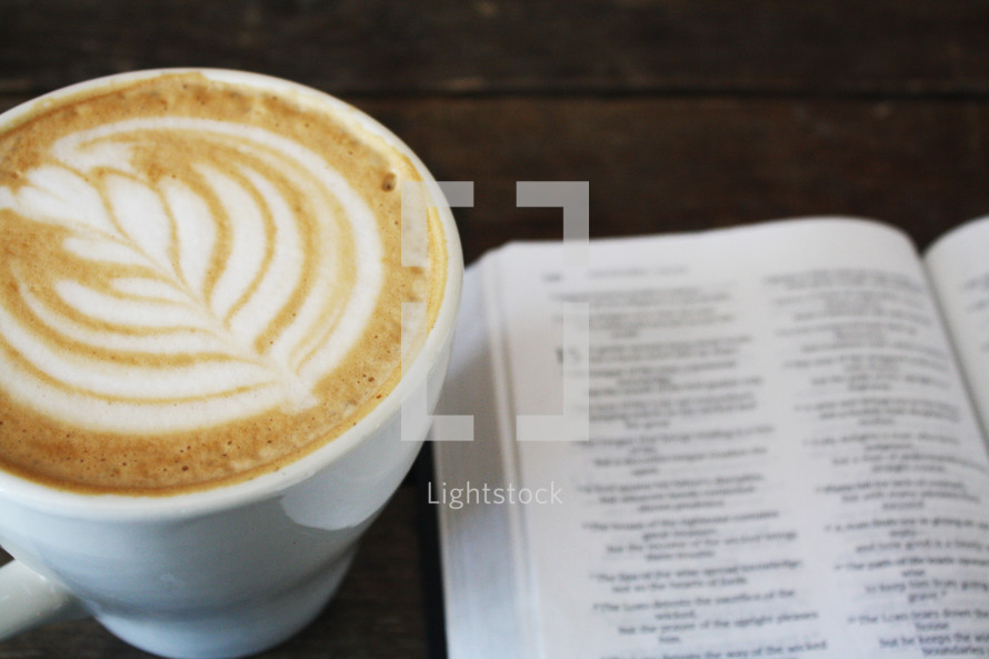 coffee cup and pages of a Bible 