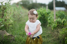 toddler girl holding a flower 