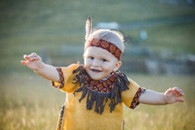 Cute Little Baby Boy dressed in Native American Clothes trying to Walk 