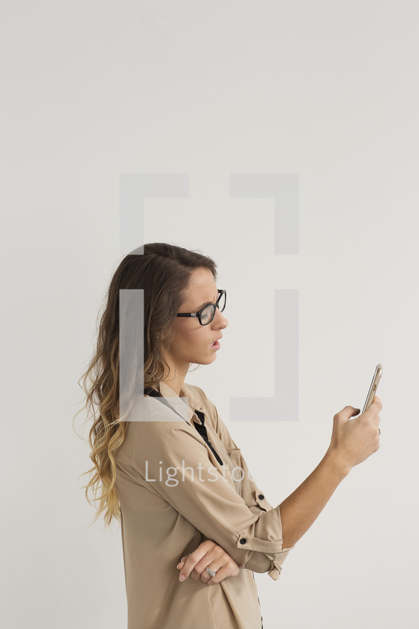 a young woman looking at a cellphone screen 