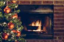 Christmas tree in front of a hearth 