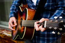 a man's hands on a guitar 