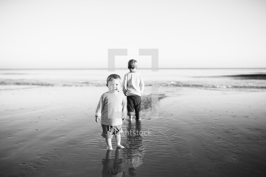 toddler boys standing in tide 