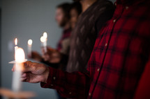 A row of people at a Christmas candlelight service.