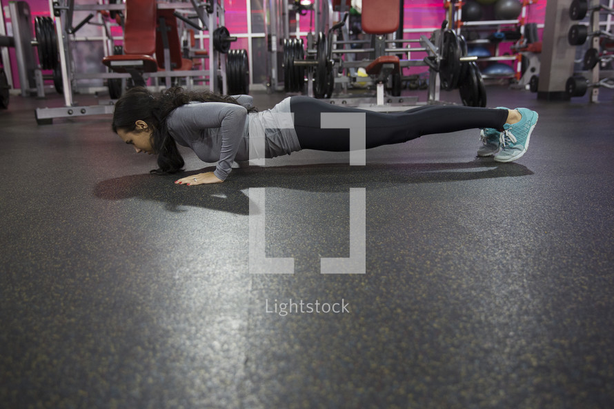 a woman doing pushups in the gym