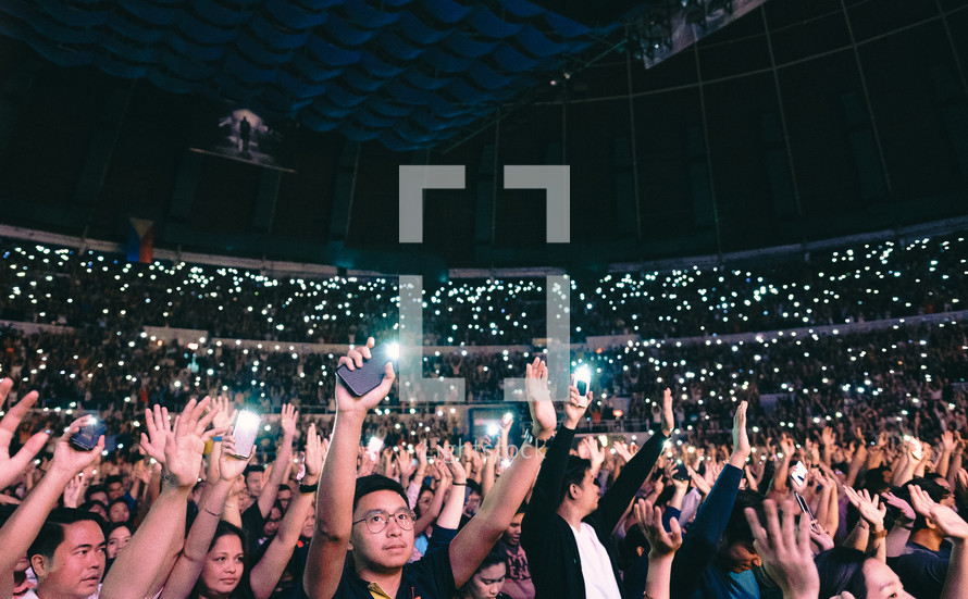 cellphone lights lighting up a concert 